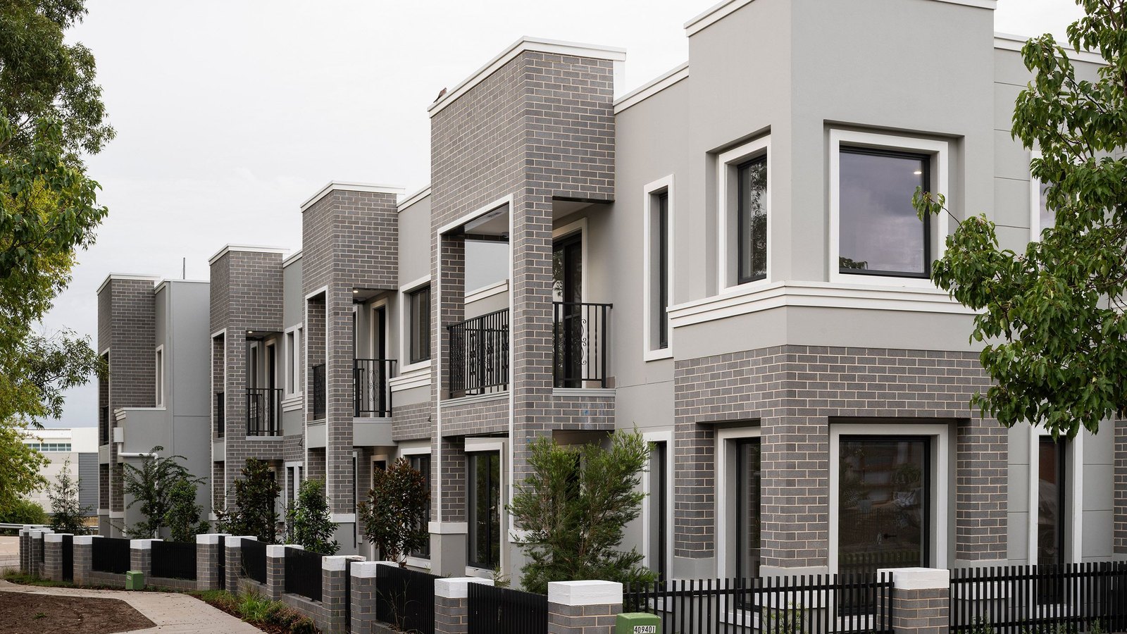 Terrace streetscape at Moffit St, Oran Park with black balcony balustrades and picket fencing